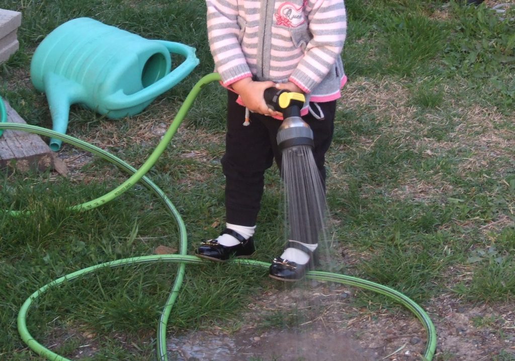 Малышка поливает огород
